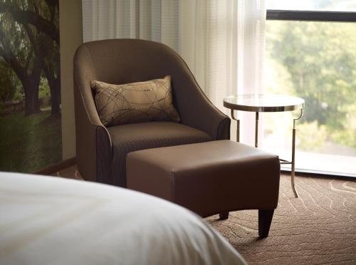 a chair and a stool in a room with a window at Atlanta Marriott Northwest at Galleria in Atlanta