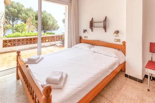 een slaapkamer met een bed en een groot raam bij Les Tonyines 68 apartamento con vistas y terraza in Llança