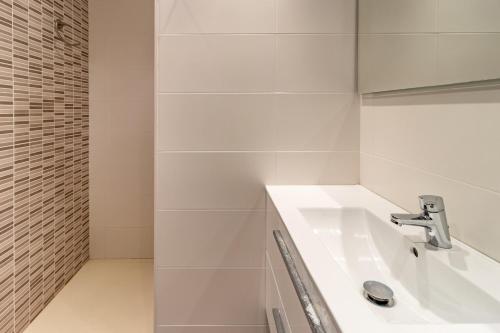 een witte badkamer met een wastafel en een spiegel bij Les Tonyines 68 apartamento con vistas y terraza in Llança