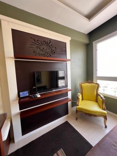 a living room with a tv and a yellow chair at Downtown Sea View Suites in Alexandria