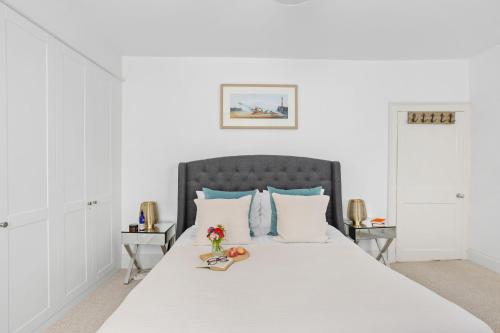 a bedroom with a large white bed with blue pillows at 10 Clarence Hill - Elegant Town House with outside space in Dartmouth