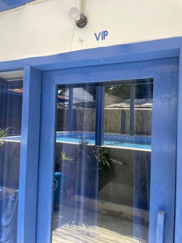a blue front door of a building with windows at Hostel Gili Trawangan - Max 2 Guest in 1 Room - with free GYM ! in Gili Trawangan