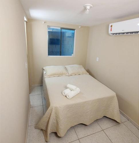 a bedroom with a bed with two towels on it at Abaré Slim Suítes in São Miguel dos Milagres
