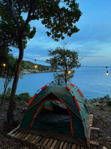 a tent sitting next to a body of water at Camping Aquarium in Himare