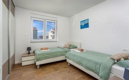 a bedroom with two beds and a window at Apartman Anavi in Sveti Vid-Miholjice