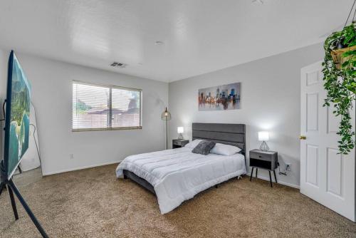 a white bedroom with a bed and a window at Great location near shopping & entertainment in Litchfield Park