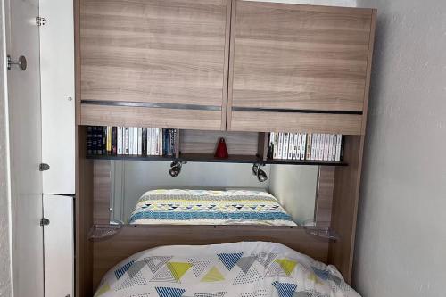 Cette chambre comprend une armoire en bois et un lit. dans l'établissement Beau studio climatisé 4 personnes, au Grau-du-Roi