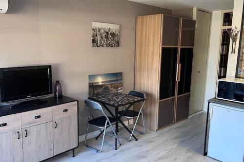 Cette petite chambre dispose d'une table, d'une télévision et d'une cuisine. dans l'établissement Beau studio climatisé 4 personnes, au Grau-du-Roi