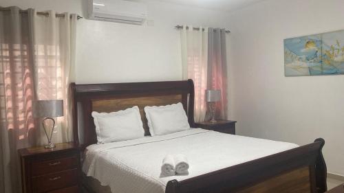 a bedroom with a bed with shoes on it at Paramount 3-Bedroom Apartment with Parking in San Felipe de Puerto Plata