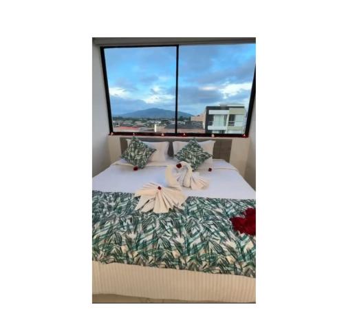 a bedroom with a bed with a large window at HOTEL CALIFORNIA in Pitalito