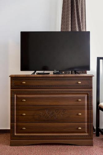 a wooden dresser with a flat screen tv on top at Popasul de Wis in Moieciu de Jos