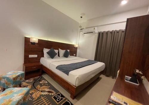 a bedroom with a bed and a chair in a room at Baga Vista in Baga