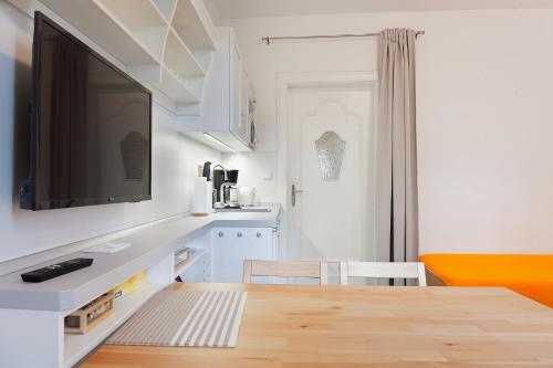 a kitchen with a table and a tv on a wall at Splavský zámeček in Staré Splavy