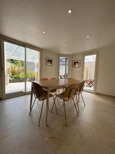 une salle à manger avec une table et des chaises dans l'établissement Maison Eole, à Bernières-sur-Mer