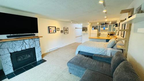 a living room with a bed and a fireplace at Cute Ski Condo at Base of Mt Alyeska Prime Location in Anchorage