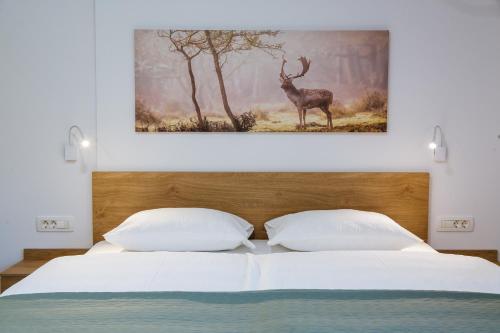 a bedroom with a bed with a picture of a deer at Domačija Log v Bohinju in Bohinjska Bistrica