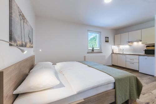 a white bedroom with a large bed in a room at Domačija Log v Bohinju in Bohinjska Bistrica