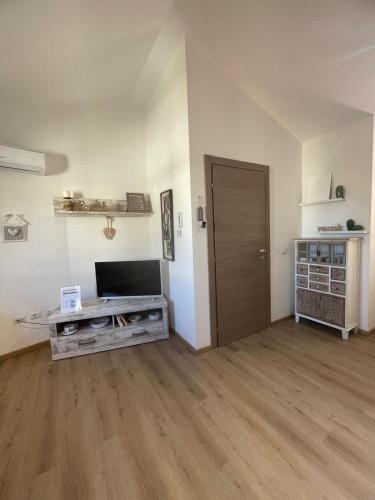 an empty living room with a television and a door at Sophie Home - Comfort e Relax a pochi km da Nora in Pula