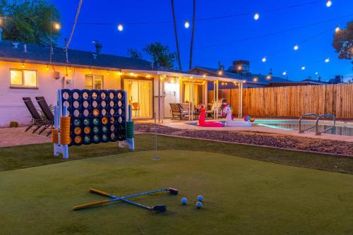 a backyard with a game of checkers and a pool at Sunshine Oasis! Heated Pool, Mini Golf, Sleeps 12 in Scottsdale