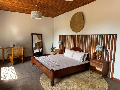 a bedroom with a large bed and a mirror at Njombe Cozy House in Njombe