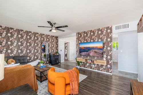 a living room with a couch and a tv at Sunshine Oasis! Heated Pool, Mini Golf, Sleeps 12 in Scottsdale