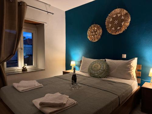 a bedroom with a bed with a bottle of wine on it at Neni's House in Prinos