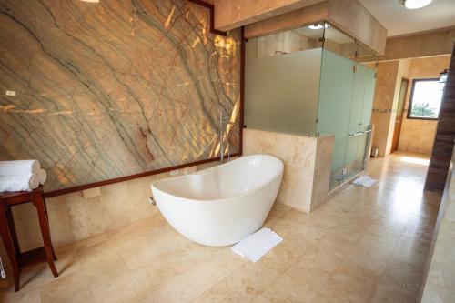 a bathroom with a large tub and a shower at Paradise Hot Springs - Thermal Water & Volcano Views in Fortuna