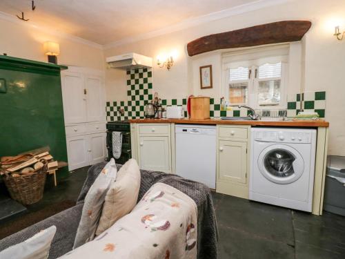 a kitchen with a sink and a washing machine at Gardeners Cottage in Millom