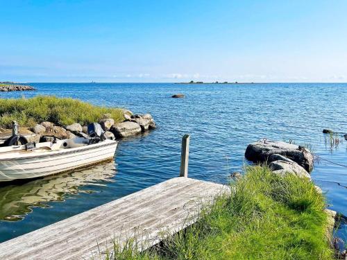 a boat on the water next to a dock at 8 person holiday home in BERGKVARA in Bergkvara