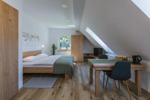 a bedroom with a bed and a desk and a table at Domačija Log v Bohinju in Bohinjska Bistrica