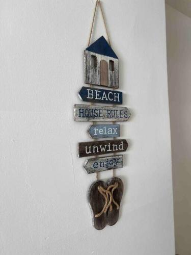a sign for a beach house with a house rules and a house rules relay unwanted at Bueno Paradise Condo In Marbella in Juan Dolio