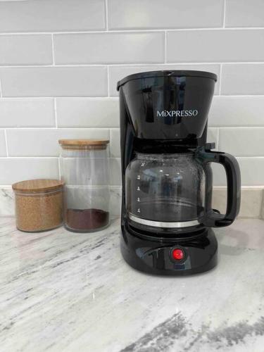 a black coffee maker sitting on top of a counter at Bueno Paradise Condo In Marbella in Juan Dolio