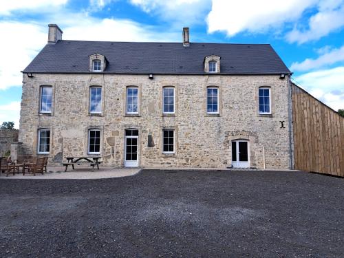 - un grand bâtiment en pierre avec une table de pique-nique devant dans l'établissement maison de vacance à mosles, à Mosles