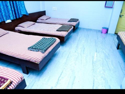 a group of four beds in a room at Krishna yatri Niwas in Akalkot