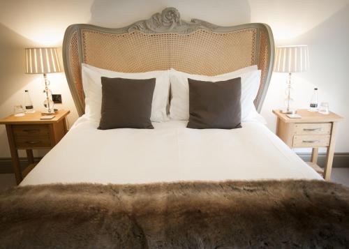 a bedroom with a large bed with white sheets and pillows at The Priory in Middleham