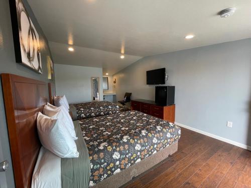 a hotel room with a bed and a flat screen tv at Sunny Sands Inn in Costa Mesa