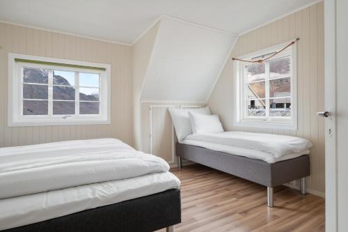 a bedroom with two beds and two windows at Aurland Guesthouse in Aurland
