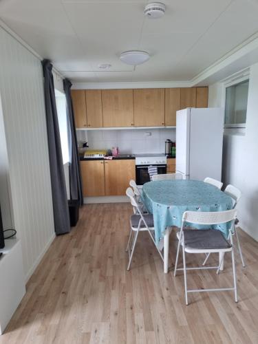 een keuken met een tafel en stoelen en een koelkast bij Not far from famous Pulpit Rock and Stavanger in Strand
