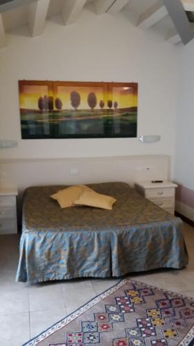 a bedroom with a bed with a painting on the wall at Sweet Home in Treviso