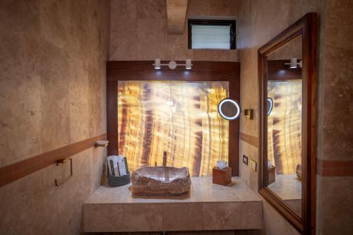 a bathroom with a mirror and a rock on a counter at Paradise Hot Springs - Thermal Water & Volcano Views in Fortuna