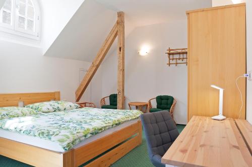 1 dormitorio con 1 cama, mesa y sillas en Splavský zámeček en Staré Splavy