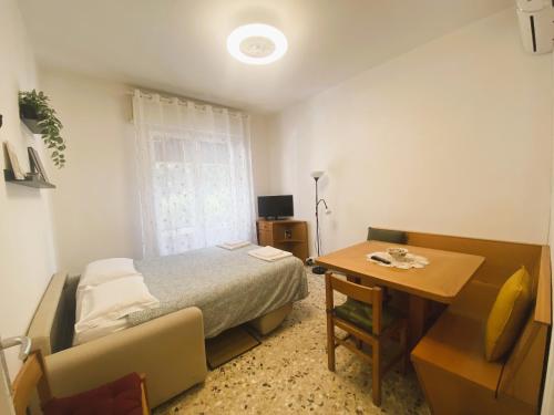 una camera con letto, scrivania e tavolo di Ad Agio Apartments a Pisa