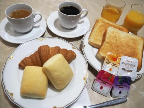 a table with two plates of toast and two cups of coffee at Hotel Tetora Tsurumi - Vacation STAY 37288v in Yokohama