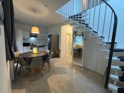 ein Esszimmer und eine Küche mit einem Tisch und einer Treppe in der Unterkunft Ferienhaus Usedom Familie Stopp Haus 23 in Lütow