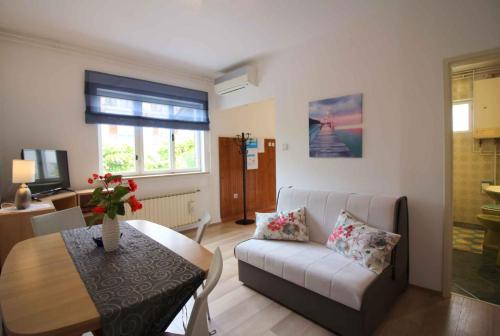 uma sala de estar com um sofá e uma mesa em Apartment in Porec/Istrien 10030 em Porec
