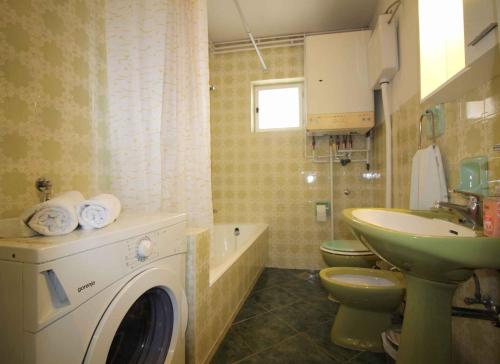 uma casa de banho com uma máquina de lavar roupa e um lavatório em Apartment in Porec/Istrien 10030 em Porec