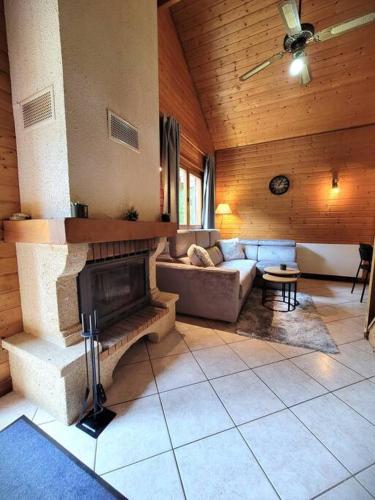 un salon avec un canapé et une cheminée dans l'établissement Chalet Goutelle, paisible en pleine nature, à Gérardmer