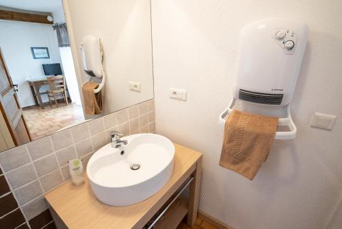 a bathroom with a sink and a phone on the wall at Le Pailler Chambres D'hôtes Restaurant Gîte piscine & spa in Verrières