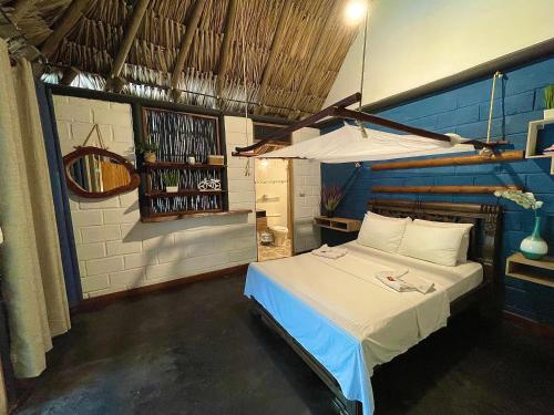 1 dormitorio con 1 cama con pared azul en Bikini Hotel & Pool en Palomino
