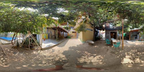 a playground with chairs under a tree in front of a building at Paziflora Hostel -STARLINK- in Puerto Escondido
